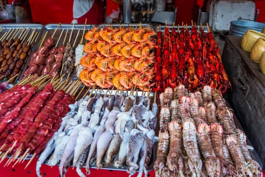 Roasted, fried and raw insects, silkworms, scorpions, bugs, snakes, shrimps, crabs, langoustes, dog meat, octopus on stick as snack street food in China