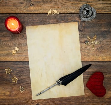 Antique blank preachment, red lit candle, red cuddle heart, wooden decorations, detailed silver quill stand in shape of hart, ornamented silver and black quill on antique oak