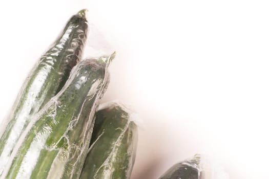 Bunch of cucumber wrapped in plastic films, isolated on white background