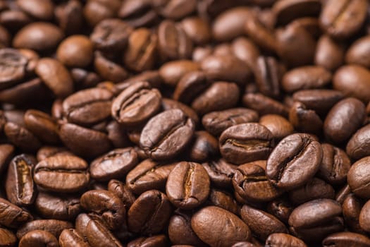 Roasted organic whole dark coffee beans, close up