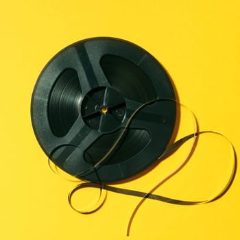 reel-to-reel tape in spool on a yellow background