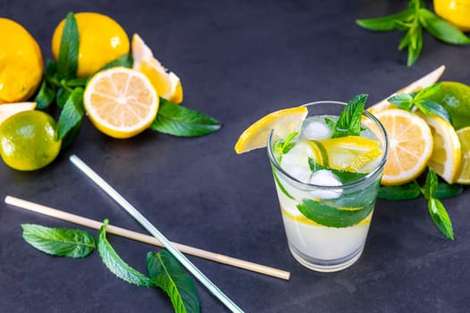 Top view of fresh lemonade with mint and ice in glasses on black background. Focus on ice.
