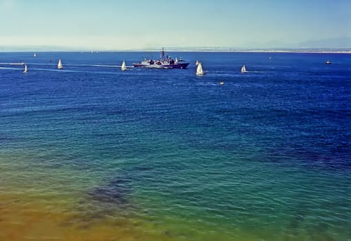 Navy ship and sailboats on Pacific Ocean, California