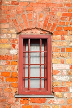 Old window with brick house wall and window bars