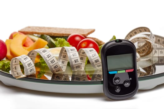 Still life with healthy food, scales, measuring tape and blood glucose meter on white background. Concept: control of level glucose. Healthy lifestyle, healthy food, slimming