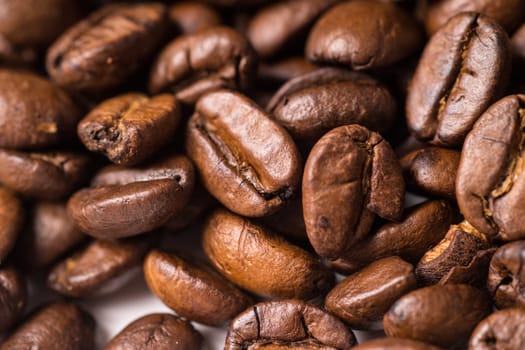 Roasted organic whole dark coffee beans, close up