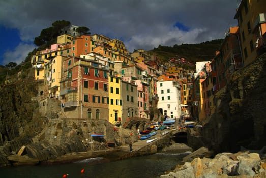 Riomaggiore, Italy - 11 November, 2006: Buildings in the city of Riomaggiore. It is one of the five famous colorful villages of the Cinque Terre National Park in Italy. With sky covered by clouds.
