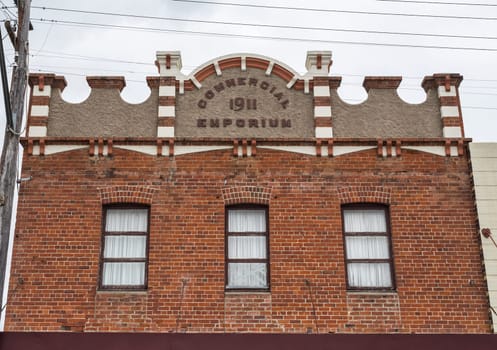 Beautiful facade of a 1911 brick building with rendered parapet and pediment, in Tenterfield, New South Wales, Australia