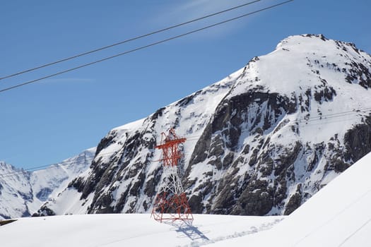 Pylon and ropes of the glacier railway between the towering mountains