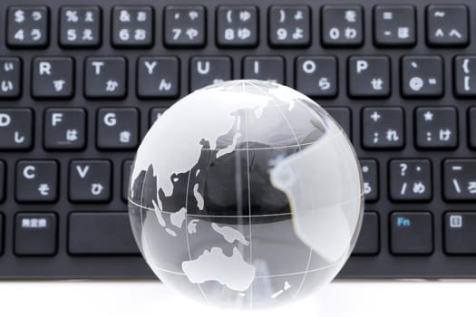 Glass globe ball with keyboard on white background
