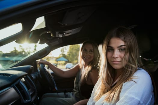 Mother and daughter inside their car going for a drive.
