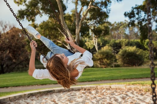 Teenage girl using a swing.