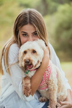 A close up portrait of an adorable puppy dog with her teenage owner.
