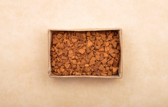 Instant Coffee in paper box on brown background