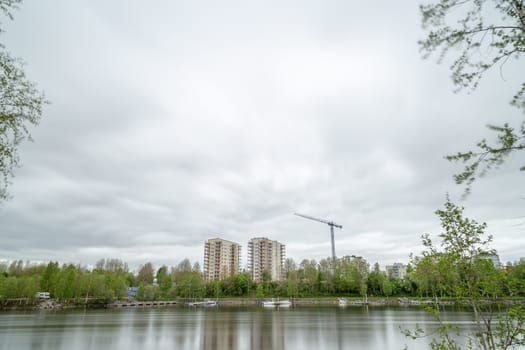Appartment Buildings by River Under Construction with a cloudy sky.