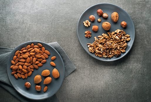 Assortment of nuts in plate. Hazelnuts, walnuts and almonds