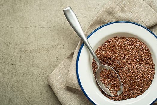 Brown flaxseed in spoon. Organic superfood for healthy eating.