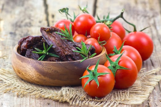 fresh and dried tomatoes on wooden background