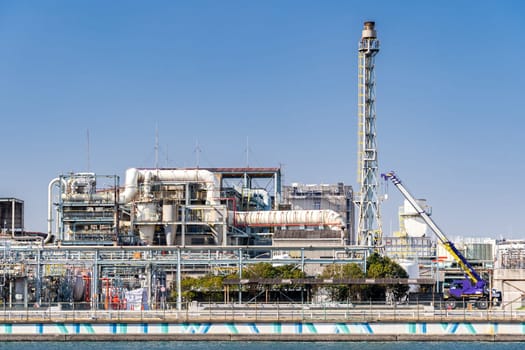 Chemical Factory plant with gas storage and structure of pipeline with smoke from smokestack in Kawasaki City near Tokyo Japan