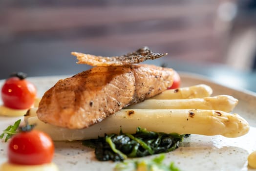 Grilled Salmon Fillet with grilled white asparagus serve with tomato and spinach