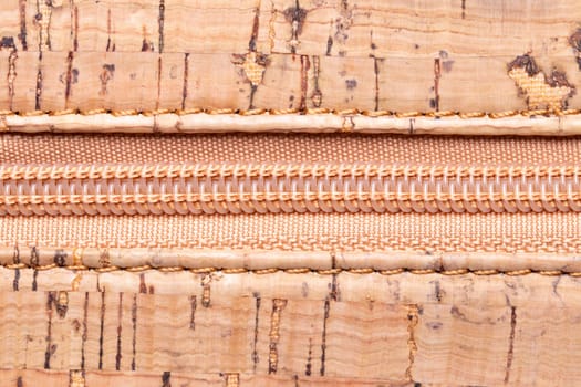 Close up of zipper. A high-resolution closeup of a detail from a closed zipper on a handbag made of natural cork. Macro photo.