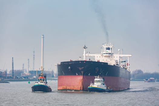 Big Cargo Containers Boat with Goods cargo Stack at the Pier docks port waiting for international sea freight transportation in Rotterdam Port of Netherlands