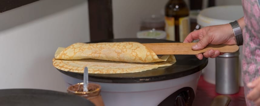 Prepare crepes on a hot plate and fold with a long wooden spoon