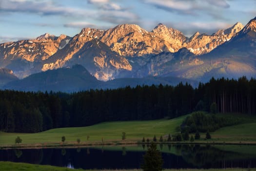 Shortly before sunset, the sun still illuminates the summit of the mountains.