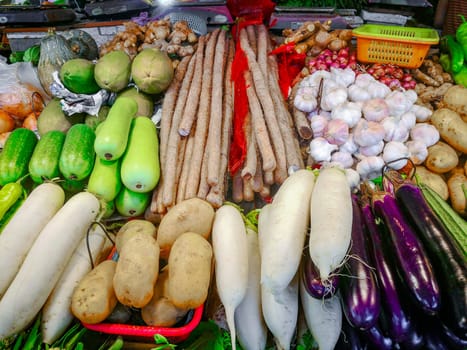 A counter with fresh vegetables in a Chinese market, farm products, greens and vegetables