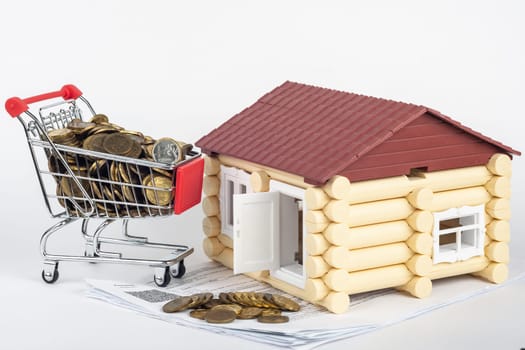 Trolley with money on the bills for the apartment, next to the toy house
