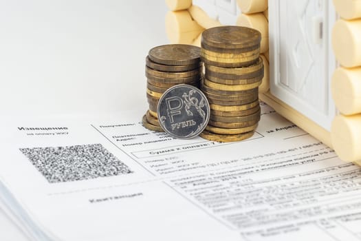 A stack of money and one ruble coin in the bills for an apartment