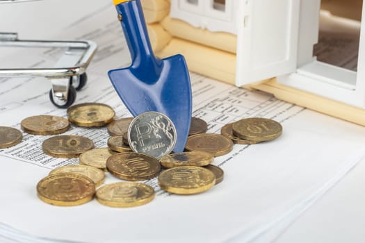 There is a ruble coin on the shoulder, next to the bills for the apartment and the toy house
