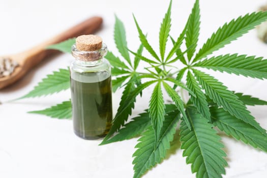 Cannabis oil in small bottle with cannabis leaves.