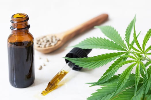 Cannabis oil in dropper with small bottle and cannabis leaves.