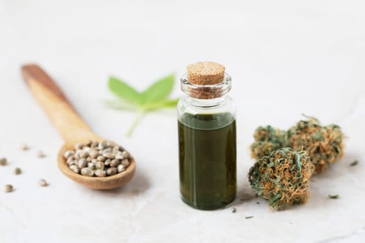 Cannabis oil in small bottle with cannabis bud and seeds
