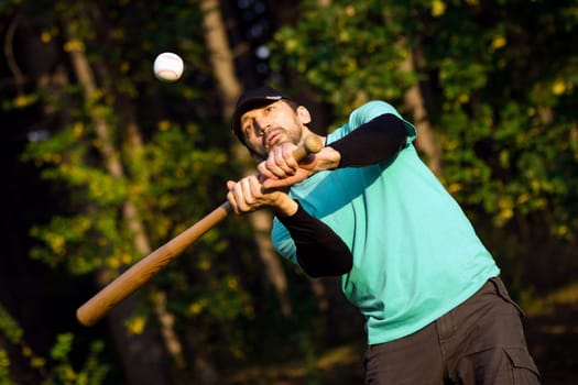 The baseball player is playing baseball as recreation in park in nature.