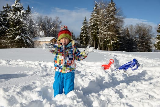 little 3 year old child playing in the snow