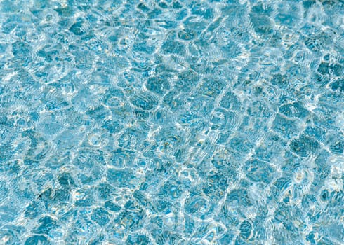 Abstract turquoise pool water ripple with sun reflection background