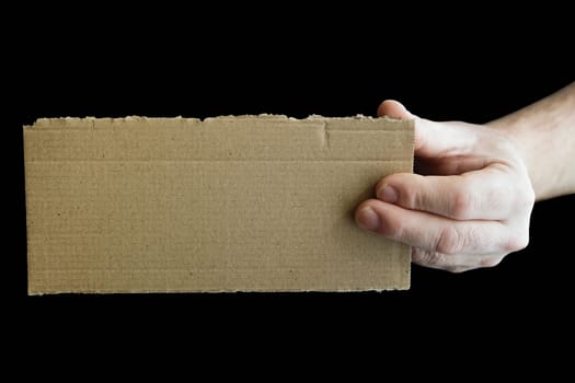 a hand holding a cardboard signboard with copy space and black background