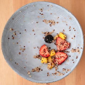 Almost emptly bowl with remnants of a quinoa fruit salad, image 8 of 8