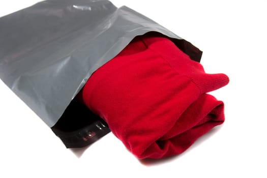 red jumper packed in gray mailing bag