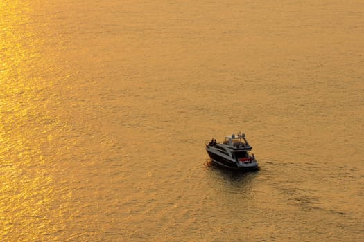 The sunset at the sea surface reflects the sun in gold. the tourist Park the boat to see the beauty of the sun.