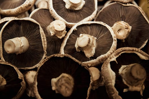 A close-up shot of an abundance of fresh Mushrooms on display at a market stall.
