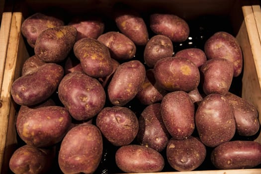 A close-up shot of an abundance of fresh red potatoes on display at a market stall.