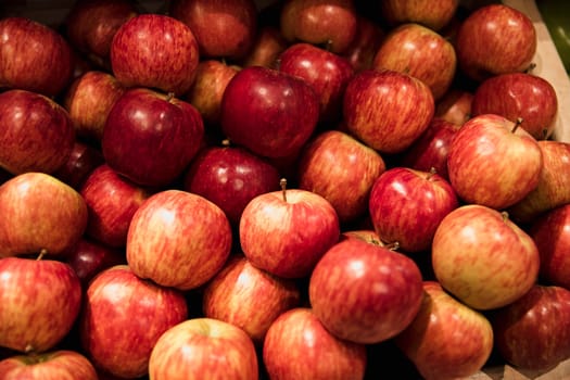 A close-up shot of an abundance of fresh Red Apples on display at a market stall.