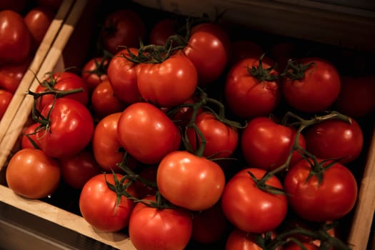 A close-up shot of an abundance of fresh Red Tomatoes on display at a market stall.