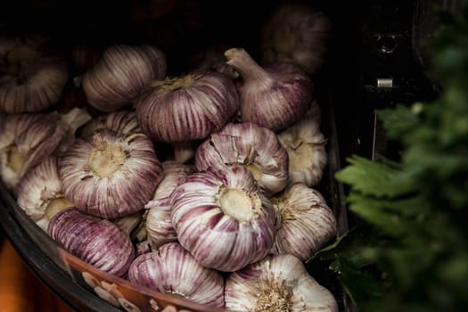 A close-up shot of an abundance of fresh garlic bulbs on display at a market stall.