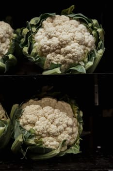 A close-up shot of an abundance of fresh cauliflower on display at a market stall.