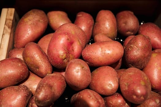 A close-up shot of an abundance of fresh red potatoes on display at a market stall.
