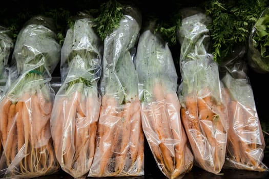 A close-up shot of an abundance of fresh carrots on display at a market stall.